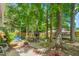 Spacious backyard featuring mature trees, a seating area, a playhouse, and a trampoline at 1703 Keogh St, Burlington, NC 27215