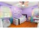 Adorable purple bedroom featuring hardwood floors, a rainbow theme, and plenty of space to play at 1703 Keogh St, Burlington, NC 27215