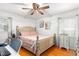 Bright bedroom featuring hardwood floors, a ceiling fan, and a light pink bedspread with matching pillows at 1703 Keogh St, Burlington, NC 27215