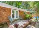 Relaxing backyard patio featuring two chairs, mature landscaping, and access to the swimming pool at 1703 Keogh St, Burlington, NC 27215