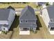 A gray two-story home boasts a well-kept backyard, a screened in porch, and green grass at 1740 Golden Honey Dr, Wake Forest, NC 27587