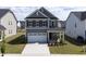 An eye-level view of a two-story home, with a two-car garage and well-kept lawn at 1740 Golden Honey Dr, Wake Forest, NC 27587
