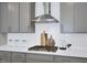 Close-up of kitchen with stainless steel range hood, gas cooktop, and white subway tile backsplash at 1740 Golden Honey Dr, Wake Forest, NC 27587
