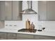 Close-up of kitchen with stainless steel range hood, gas cooktop, and white subway tile backsplash at 1740 Golden Honey Dr, Wake Forest, NC 27587