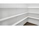 Walk-in pantry with built in white shelving and wood floors at 1740 Golden Honey Dr, Wake Forest, NC 27587