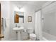 Charming bathroom featuring a pedestal sink, toilet, and shower with tub, blending functionality with classic design at 201 Red Bud Ln, Chapel Hill, NC 27514