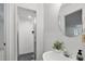 Bathroom featuring shower with glass door, white sink and vanity, round mirror, and light, neutral paint at 201 Red Bud Ln, Chapel Hill, NC 27514