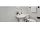 Neutral bathroom features pedestal sink, round mirror, toilet, and fresh bright paint at 201 Red Bud Ln, Chapel Hill, NC 27514