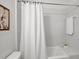 Bathroom with white tiles, bathtub, and shower curtain featuring a calming, spa-like retreat in neutral tones at 201 Red Bud Ln, Chapel Hill, NC 27514
