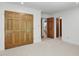 Bedroom with neutral carpet and beautiful wood doors leading to the hallway and closet at 201 Red Bud Ln, Chapel Hill, NC 27514