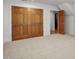 Bedroom featuring neutral carpet, large closet with wood doors, and access to a walk-in closet at 201 Red Bud Ln, Chapel Hill, NC 27514