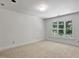 Bedroom featuring neutral carpet and views of lush greenery from the large window at 201 Red Bud Ln, Chapel Hill, NC 27514