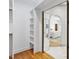 Closet with shelves and a mirror, leading to bedroom with ensuite bathroom, offering easy access and convenience at 201 Red Bud Ln, Chapel Hill, NC 27514