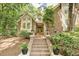 Inviting brick stairs lead to the front door of this charming home surrounded by lush greenery at 201 Red Bud Ln, Chapel Hill, NC 27514