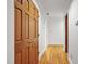 Hallway with hardwood floors featuring a closet with wood doors, and a door leading to another room at 201 Red Bud Ln, Chapel Hill, NC 27514
