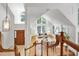 Inviting living room with vaulted ceilings, abundant natural light, and fireplace, seen from the staircase at 201 Red Bud Ln, Chapel Hill, NC 27514