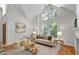 Sunlit living room with high ceilings, fireplace, hardwood floors, and elegant decor at 201 Red Bud Ln, Chapel Hill, NC 27514