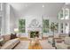 Bright living room featuring a fireplace, hardwood floors, neutral decor, and large windows at 201 Red Bud Ln, Chapel Hill, NC 27514