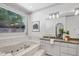Elegant bathroom with marble-surround tub, granite countertops, and natural light from a window at 201 Red Bud Ln, Chapel Hill, NC 27514
