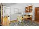 Bright office featuring white walls, light-colored wood flooring, an area rug and built-in desk and shelving at 201 Red Bud Ln, Chapel Hill, NC 27514