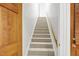 Carpeted stairway with wooden handrail leads to the upper level of the home at 201 Red Bud Ln, Chapel Hill, NC 27514