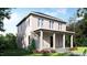 Two-story home with covered porch, neutral siding, and beautifully landscaped front yard at 203 E Winmore Ave, Chapel Hill, NC 27516