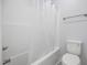 Toilet and bath/shower combination with a shower curtain in a neutral bathroom at 208 W Holt St, Burlington, NC 27217