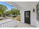 Cozy front porch featuring a black door, white railings, and house number at 208 W Holt St, Burlington, NC 27217