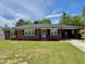 Charming brick home with a well-maintained lawn and blue sky at 213 N Brevard St, Selma, NC 27576