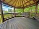 Wooden gazebo interior showcasing a swing bench, seating, and views of the surrounding yard at 213 N Brevard St, Selma, NC 27576