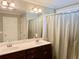 Bathroom with double vanity, large mirror, and shower with curtain at 2193 Boyd Creek Dr, Graham, NC 27253
