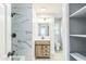 Bathroom with a wood vanity, marble tile, and an updated light fixture at 2300 Radius Cir, Sanford, NC 27330