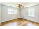 Cozy bedroom features hardwood floors, a ceiling fan, and natural light from two windows at 2300 Radius Cir, Sanford, NC 27330