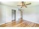 Bedroom featuring hardwood floors, a ceiling fan, and white closets at 2300 Radius Cir, Sanford, NC 27330