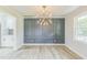Stylish dining room featuring modern lighting, paneled accent wall, neutral walls, and wood flooring at 2300 Radius Cir, Sanford, NC 27330
