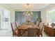 Stylish dining room featuring modern lighting, paneled accent wall, neutral walls, table setting, and wood flooring at 2300 Radius Cir, Sanford, NC 27330