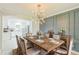 Stylish dining room featuring modern lighting, paneled accent wall, neutral walls, wood table, and view of updated kitchen at 2300 Radius Cir, Sanford, NC 27330