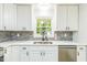 Kitchen with stainless appliances, white cabinets, and gray backsplash at 2300 Radius Cir, Sanford, NC 27330