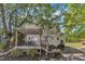 Charming backyard featuring a covered deck, lush landscaping, and mature trees at 24 W Canterbury Ct, Wendell, NC 27591