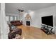 Bright living room with hardwood floors, a fireplace, ceiling fan and modern leather furniture at 24 W Canterbury Ct, Wendell, NC 27591