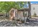 View of the outbuilding with a cozy covered porch and red door, adds character to the yard at 24 W Canterbury Ct, Wendell, NC 27591