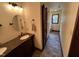 Tasteful bathroom featuring a granite sink, modern lighting, and a tiled shower at 2483 Mcneill Hobbs Rd, Bunnlevel, NC 28323