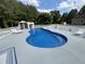 Backyard pool area with a custom waterfall feature, complemented by lounge chairs and a privacy fence at 2483 Mcneill Hobbs Rd, Bunnlevel, NC 28323