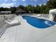 Backyard pool complete with a custom waterfall, lounge chairs, and a covered patio for shaded relaxation at 2483 Mcneill Hobbs Rd, Bunnlevel, NC 28323