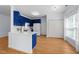 Open kitchen with blue cabinets, a breakfast bar, white appliances, and hardwood floors at 2536 Bent Green St, Raleigh, NC 27614