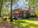 Expansive backyard featuring a screened-in porch, deck with stylish furniture, and mature trees at 266 Hogans Valley Way, Cary, NC 27513