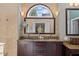 Elegant bathroom features dual sinks, granite counters, decorative stone accents, and arch window at 266 Hogans Valley Way, Cary, NC 27513