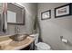 Stylish powder room with a granite vanity and unique glass vessel sink and dark wood cabinetry at 266 Hogans Valley Way, Cary, NC 27513