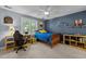 Youthful bedroom with blue walls, white trim, ceiling fan, desk, and decorative shelves at 266 Hogans Valley Way, Cary, NC 27513