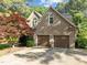 Two-car garage with brick exterior and well-maintained driveway, surrounded by mature trees at 266 Hogans Valley Way, Cary, NC 27513